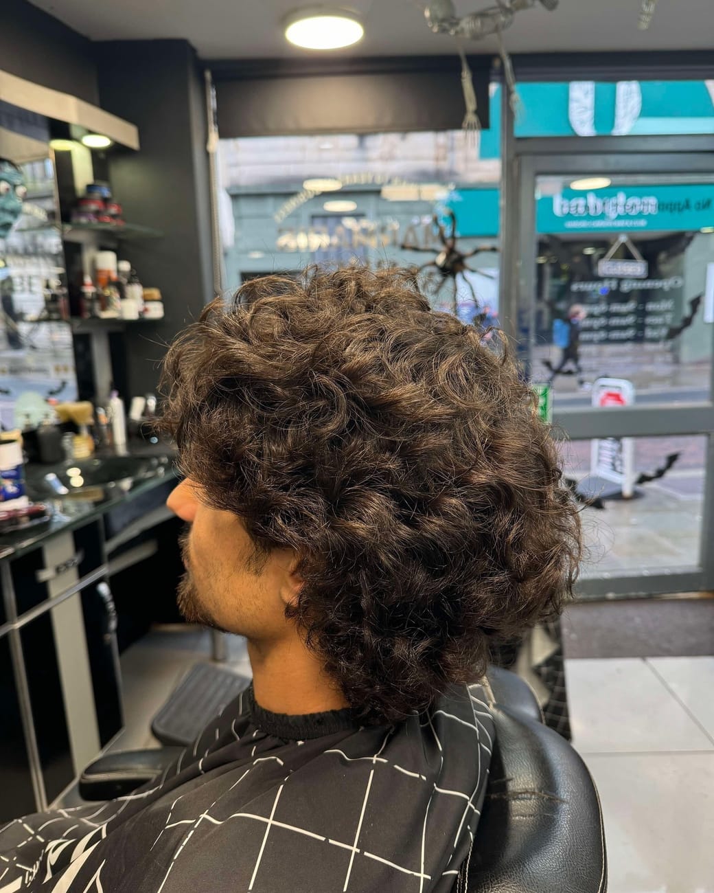 A client with long curly hair, side on, before the cut at Marmaris
